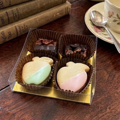 Vintage teapot, books, and pastel apple-shaped shortbread and pecan squares on a wooden table